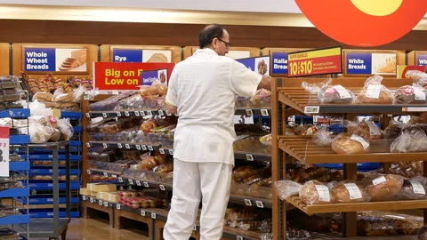 Motion of worker stocking bread at display rack inside superstore Stock Footage 118255537