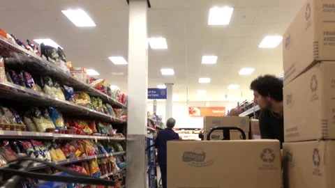 Motion of worker stocking cookies on display rack inside Walmart store Video stock 96363647