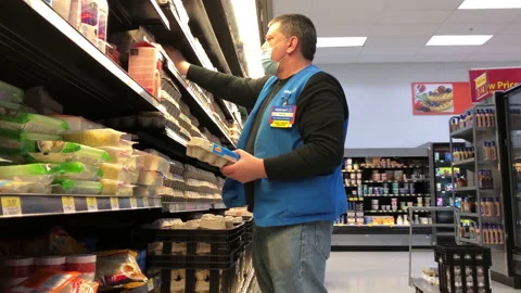 The motion of worker stocking egg on display rack inside Walmart store Stock-Footage 155771305