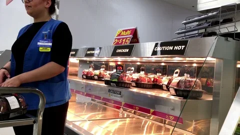 Motion of worker stocking roasted seasoned chickens for sale Video stock 72396186