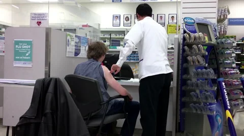 Motion of young man having flu shot at pharmacy section Video stock 69043719