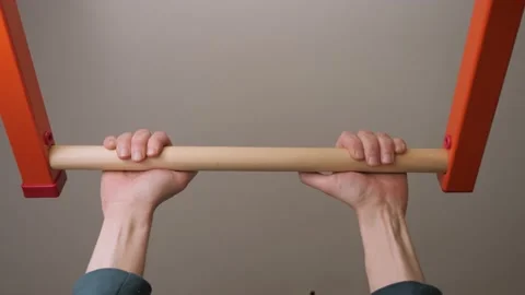 Motivated man doing pulling up on horizontal bar at home gym face effort sport 動画素材 151274757