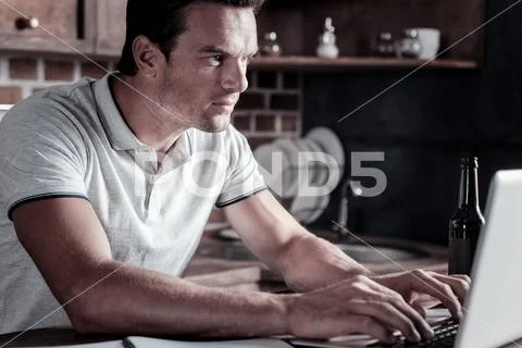 Motivated millennial guy working on laptop Stock Photos