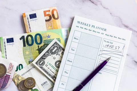 Motivational note and banknotes on a weekly planner Stock Photos