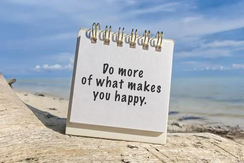 Motivational quote on notepad with text 'Do more of what makes you happy" Stock Photos