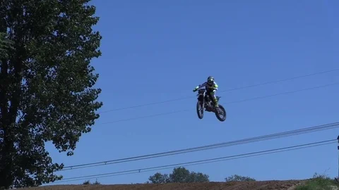 Moto cross bikers are jumping over hill Stock Footage 82075615