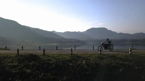 A motobike run pass be side a lake in Chiang Mai, Thailand Stock Footage 100851724