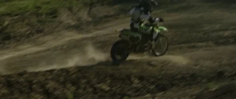 Motocross racer taking a turn while racing on a muddy road track in slow motion Stock Footage 69202143