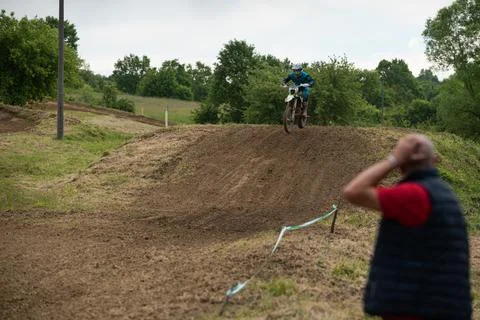 Motocross riders on muddy track during overcast day Stock Photos