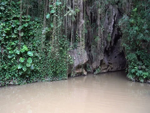 Motor boat is leaving the underground cave in tropical jungle Stock Footage