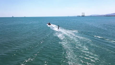 Motor boat pulls a surfer riding the water surface on his board Stock Footage 202625633