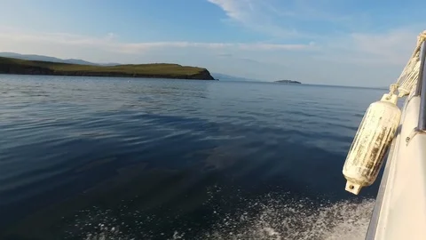 Motor boat sailing. Smooth surface of lake Baikal. Water splashes from boat. Video stock 126349872