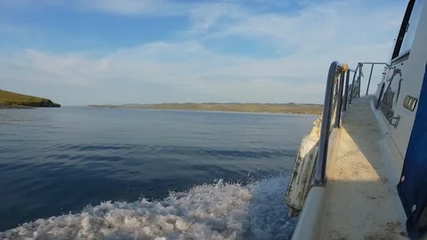 Motor boat sailing. Smooth surface of lake Baikal. Water splashes from boat. Stock Footage 126610410