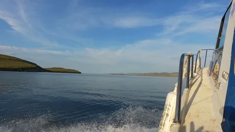 Motor boat sailing. Smooth surface of lake Baikal. Water splashes from boat. Stock Footage 127732634