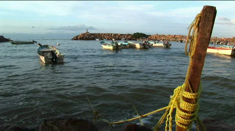 A motor boat tethered to a dock post rocks in the waves. Stock Footage 554285