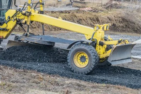 Motor grader with a blade performs the layout of a road crushed stone gravel Stock Photos