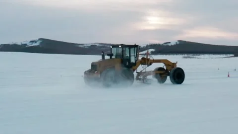 Motor Grader Crossing an Endless Snow Covered Plain Stock Footage 344955865
