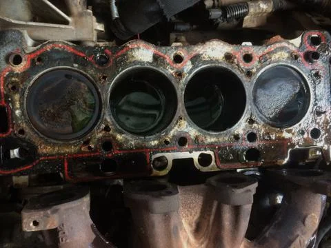 Motor vehicle engine block with old/damaged cylinder head gasket Stock Photos