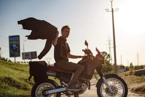 A motorbiker on the bikde waving hos jacket Stock Photos