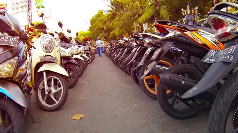 Motorbikes parked in long rows in a downtown area of Kuta, Bali Vidéo 55456545