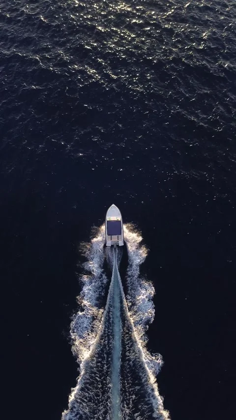 Motorboat aerial top view chasing the sunset light vertical shot Stock Footage 295349816