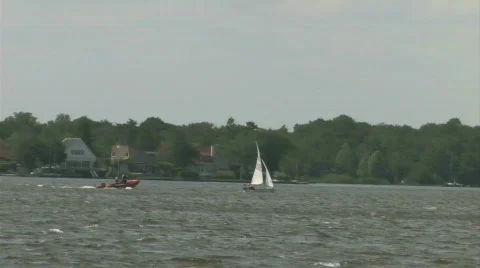 Motorboat chasing a sailboat Stock Footage 143374