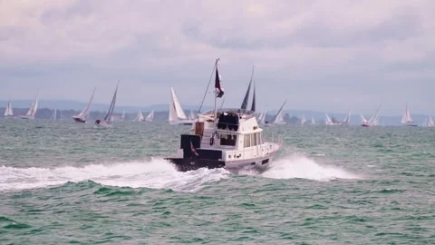 Motorboat cruiser with distant yachts round the isle of wight race Stock Footage 337936501