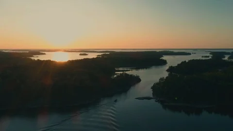 Motorboat passing through channel between islands during golden hour Video stock 114003895