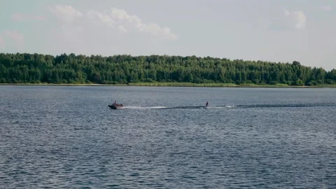 A motorboat pulls a man on water skis Stock Footage 248524897