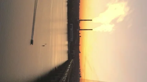 Motorboat on river after sunset. Vertical aerial of smoky plant after dawn. Video stock 203969042