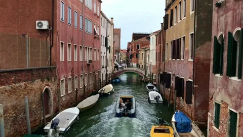 Motorboats navigating narrow canal between historic buildings in Venice Stock-Footage 342516491