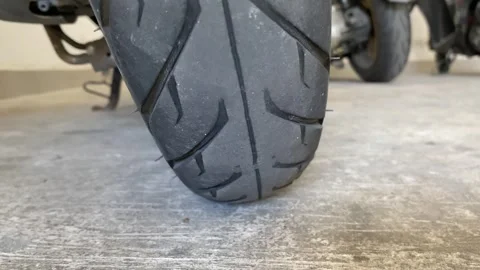 Motorcycle back tire rubber on cement ground close up view parking Stock Footage 249868230