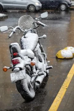 Motorcycle covered with snow. Sharp cooling, climate change. Unsuccessful time Stock Photos