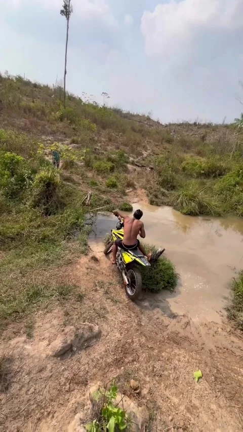 Motorcycle Crosses Puddle Only to Fall in Creek, Jacunda, Para, Brazil - 15 Dec  Stockbeeldmateriaal 328178503
