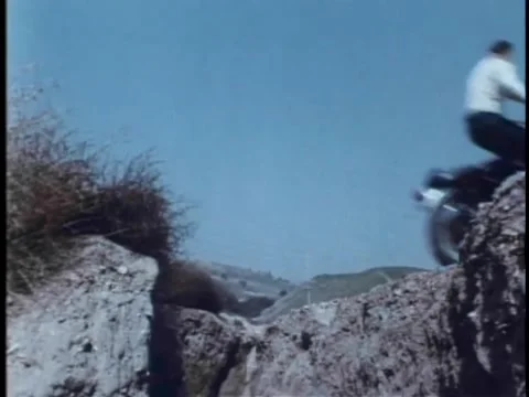 Motorcycle daredevil riding over chasm Stock Footage 260240529
