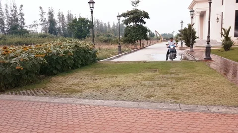 A motorcycle driver breaking traffic law by riding the motorcycle on sidewalk Stock Footage 102176285