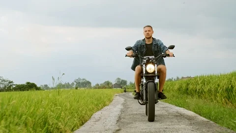 Motorcycle driver riding on a the rice fields. Outdoor shot, countryside Stock Footage 108692519