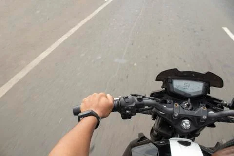 Motorcycle driver riding in Vadodara highway, handlebars view, India. Stock Photos