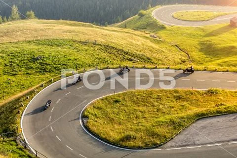 Motorcycle drivers riding in Alpine highway. Outdoor photography Stock Photos