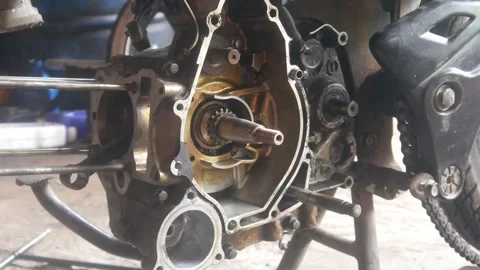 Motorcycle engine being disassembled into the magnet block and cylinder sections Stock Footage 324942082