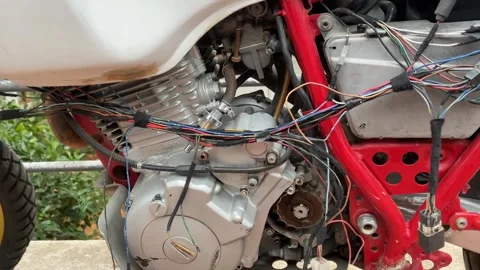 Motorcycle engine with exposed wiring and red frame, focus on mechanical de.. Stock-Footage 331297898