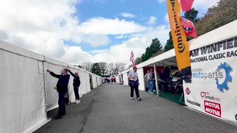 Motorcycle enthusiasts explore exhibition stands and displays during a sunny Stock Footage 316764507