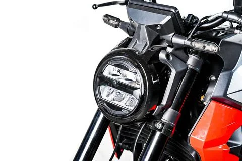 Motorcycle front headlight close up on red bike isolated on white backgroun.. Stock Photos