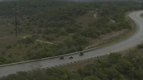 Motorcycle gang turns down winding road in the country Stock Footage 323480582