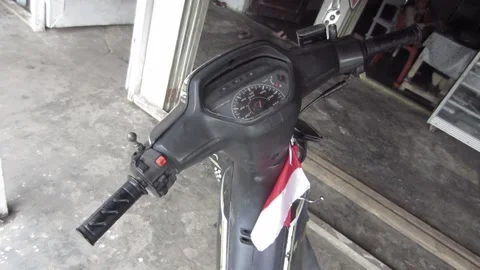 Motorcycle handlebar analog speedometer display small Indonesian flag attached Stock Footage 205542224