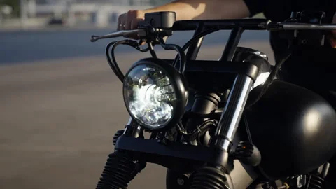 Motorcycle headlight close-up. A rare black bike covered with chrome. A man in Stock Footage 245711199