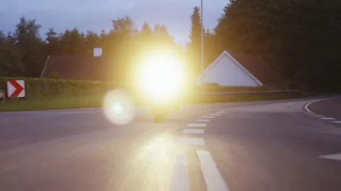 Motorcycle With Headlights Beaming Under the Dusk Skies, Full Tracking Shot Stock-Footage 157370705