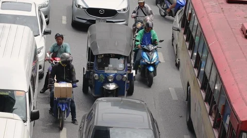 Motorcycle lane splitting at busy intersection in Sathorn Stock-Footage 115959887