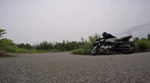 Motorcycle leanes through corner as it passes camera in slo mo Stock Footage 52139567
