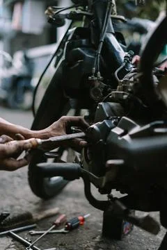 A motorcycle mechanic inspecting a damaged engine Stock Photos